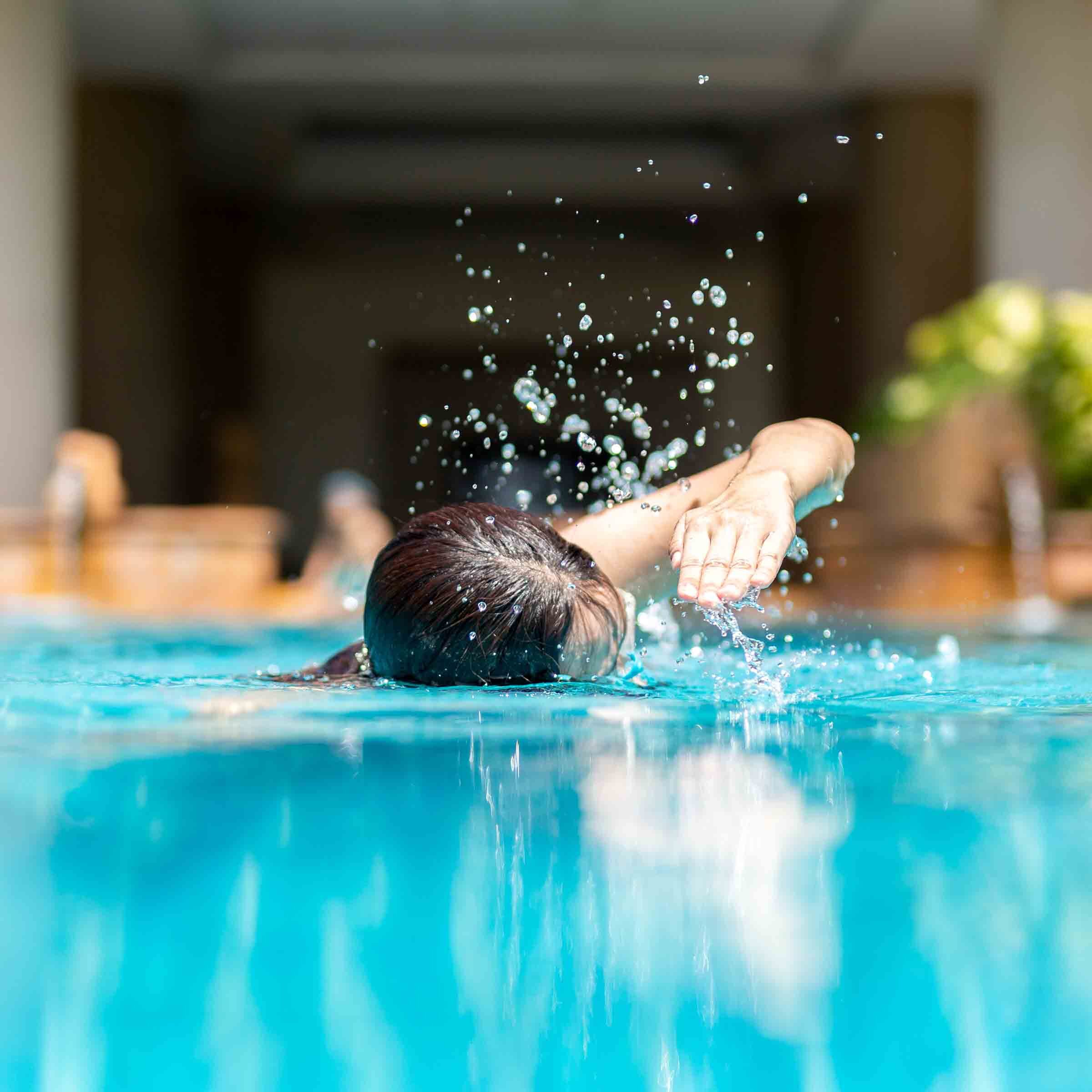 Unidentified woman doing front crawl swimming in swimming pool o
